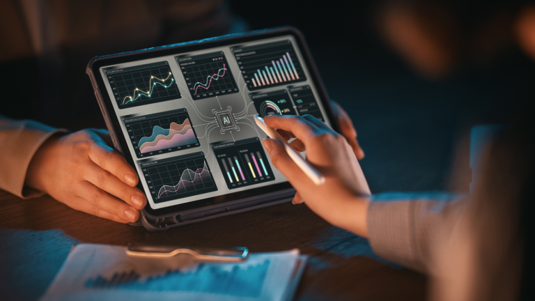 Two professionals reviewing project performance data on a tablet with charts and analytics